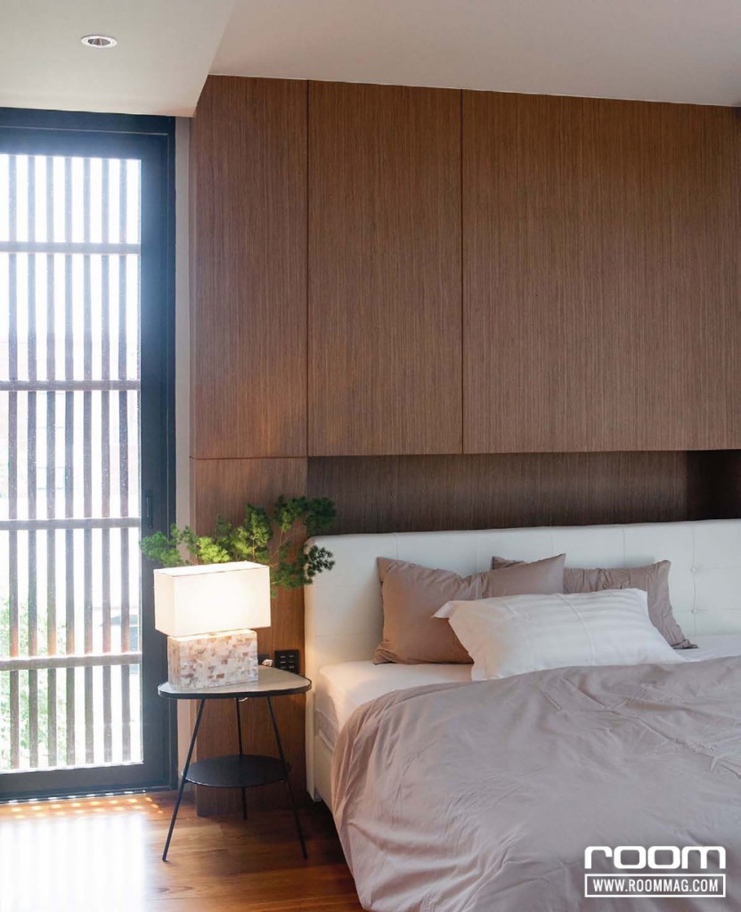 ห้องนอนหลักยังคงเล่นกับแสงและเงาที่ลอดผ่านบานเกล็ดไม้ รวมทั้งการตกแต่งภายในที่ใช้สีไม้เป็นหลัก