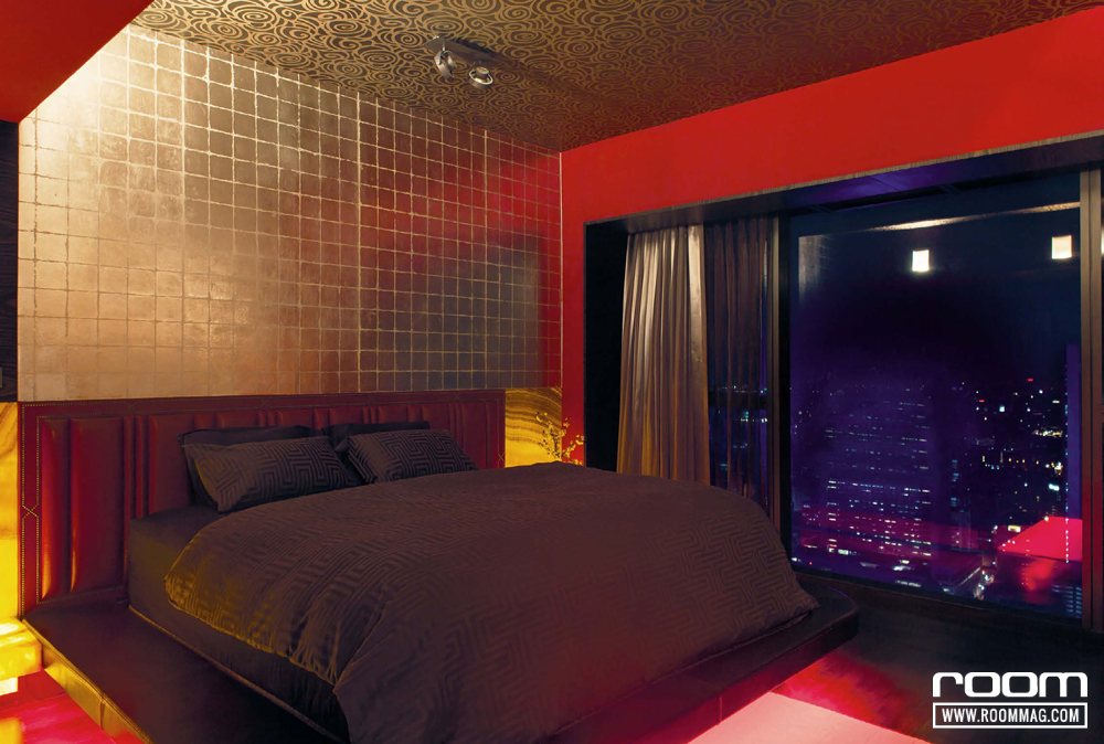 ภายในห้องนอนหลักตกแต่งหัวเตียงด้วยหนังแท้สีแดง ข้างเตียงทั้งสองฝั่งกรุหินอ่อนผิวขัดมัน และกรุวอลล์เปเปอร์เมแทลลิกสี Silver Leaf ที่ผนังหัวเตียง สร้างบรรยากาศให้ห้องนอนหลักดูลึกลับน่าค้นหา