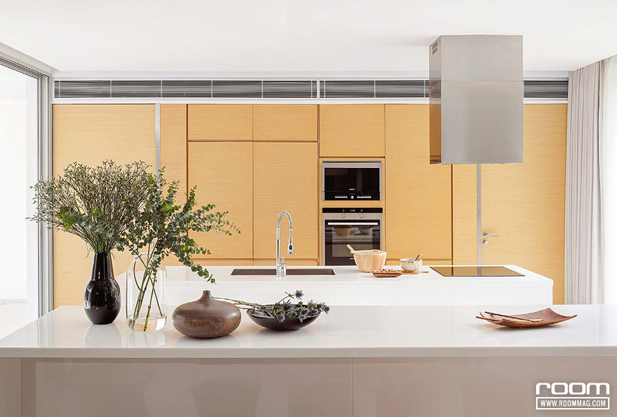 ห้องครัวดูเรียบง่ายด้วยบานตู้บิลท์อินไม้ที่เข้ากับสไตล์ของบ้าน ไอส์แลนด์หินสังเคราะห์สีขาวดูสะอาดตา สามารถใช้งานได้หลากหลายรูปแบบ 