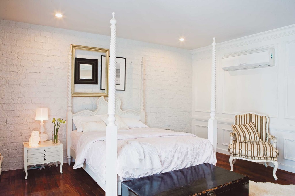 แบบห้องนอนสีขาว เตียงไม้ แต่งหัวเตียงด้วยกรอบรูป